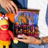 Up close of boy holding Fraggle Rock gift set next to a stuffed animal of Red. , 5 of 5