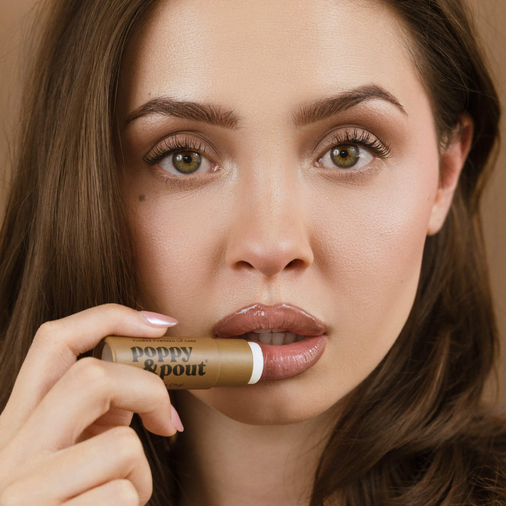 Vanilla Chai lip balm tube on lips, brown tube