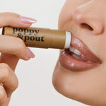 Vanilla Chai lip balm applied, hand holding brown tube with cap, 3 of 5