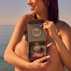 Woman Sitting near Beach and Showing Pomegranate Peach Lip Care Duo Gift Set, 5 of 5