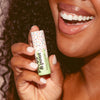 Woman holding Poppy & Pout Green Lip Balm, 2 of 4